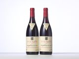 two bottles of red wine sitting on top of a table
