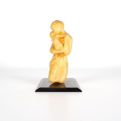 sculpture représentant une femme tenant un enfant dans ses bras, posée sur un socle noir