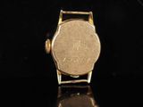 a close up of a gold watch on a black surface