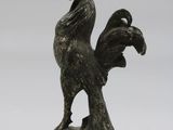 bronze statue of a rooster on a marble base on a white background