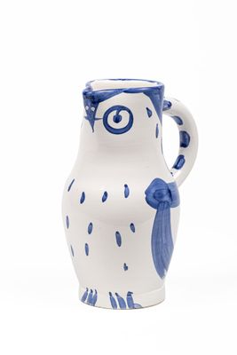un vase bleu et blanc en forme de chouette sur fond blanc