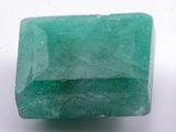 a close up of a green emerald stone on a white surface