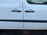 une camionnette blanche avec une bande noire, garée sur un parking