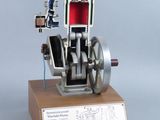 une maquette de machine à vapeur posée sur un socle en bois