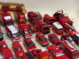 a lot of toy fire trucks that are sitting on a table