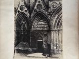 black and white photograph of an old building with a car parked in front of it
