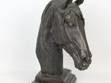 statue of a horse ' s head on a marble base on a white background