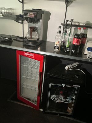 un petit réfrigérateur et un mini-réfrigérateur dans un coin de la pièce