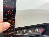 a person holding a ruler in front of a car