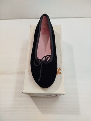 quelqu'un porte une paire de chaussures noires sur une surface blanche