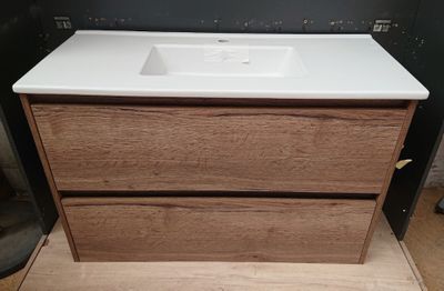 une photo d'un meuble de salle de bains avec un plan de travail blanc