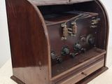an old fashioned radio with wooden case sitting on top of a table