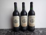 three bottles of wine sitting on top of a table next to each other