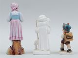 three figurines of people standing next to each other