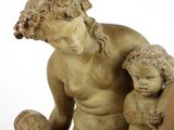statue of a woman holding a child and a dog on a white surface