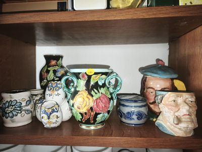 many different vases on a shelf in a room