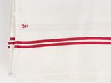 a close up of a red and white towel on a white surface