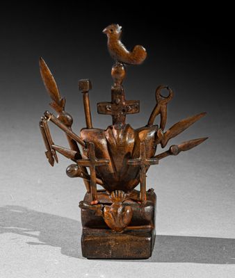 statue d'un homme avec un oiseau perché sur la tête, entouré d'outils