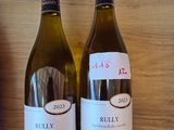 two bottles of wine that are on a shelf