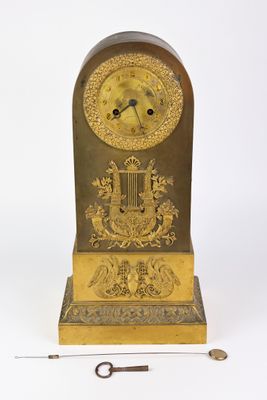 une horloge posée sur une table, avec une clé