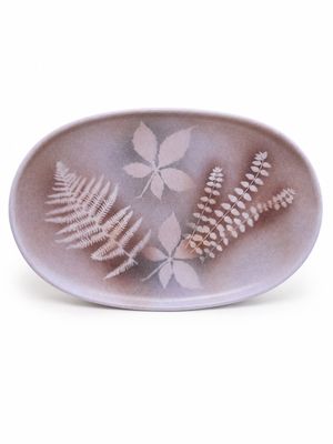une assiette blanche ornée d'un motif de feuille de fougère
