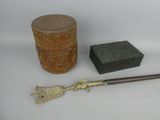 a small wooden box and a small metal object on a white surface