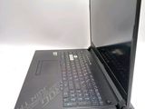 a black laptop with a purple keyboard sitting on a white surface
