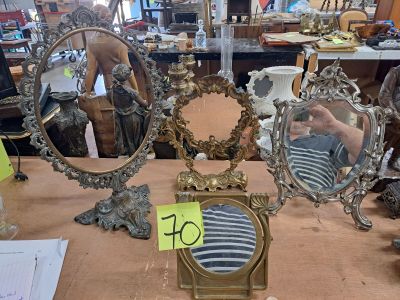une table sur laquelle sont posés de nombreux miroirs anciens