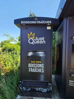 un panneau sur lequel est écrit « Just Queen » et une poubelle devant une autre poubelle