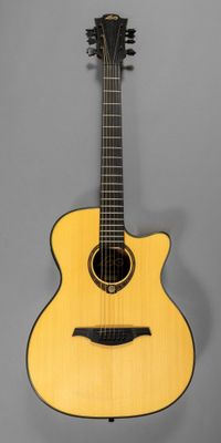a yellow acoustic guitar on a stand against a gray background