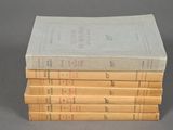 four books stacked on top of each other on a gray surface