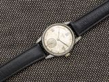 un gros plan d'une montre-bracelet posée sur un tissu noir
