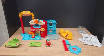a small table with toys on it that include a fire truck and a fire station
