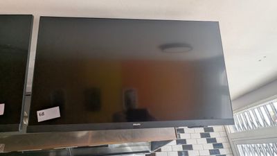 a flat screen tv mounted on the wall above a stove