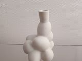 a white vase that has a bunch of white balls in it