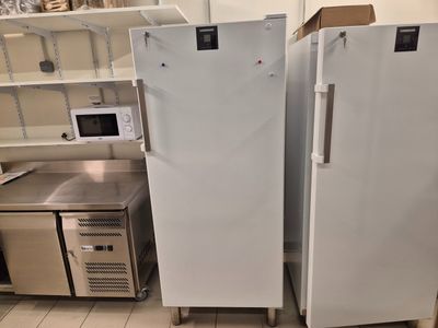 deux réfrigérateurs blancs placés côte à côte dans la cuisine