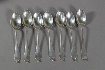 six cuillères en argent sont alignées sur une table