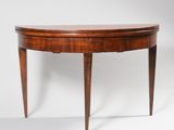 an oval mahogany table with two legs and a curved top