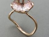 Gros plan sur une bague en or ornée d'une pierre rose