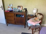 a teddy bear sitting on a chair in the corner of a room