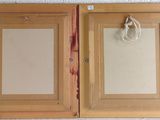 two wooden cabinets with a mirror and a bag hanging on the wall