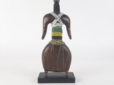 une statue en bois représentant une femme portant une écharpe verte et jaune