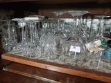 de nombreux verres à vin posés sur une étagère dans un placard