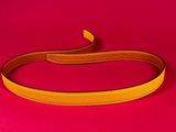 a close up of a yellow belt on a red surface