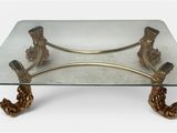 a glass table with a gold metal base and a glass top