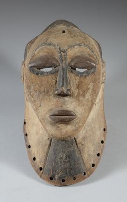 gros plan d'un masque en bois sur une surface blanche