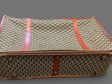a wicker box with a handle on a gray surface