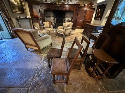 a living room with a fireplace, chairs, and a piano