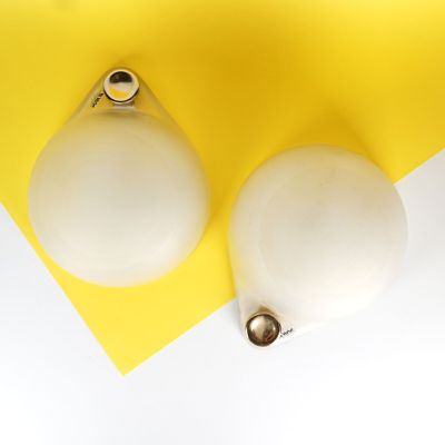 fond jaune et blanc avec deux lampes blanches posées sur une surface jaune et blanche