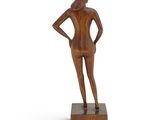 a wooden sculpture of a woman standing on a wooden base